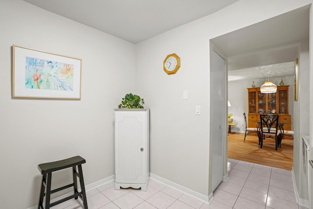 hall with light tile patterned flooring and baseboards