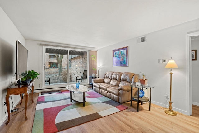 living area with visible vents, baseboards, and wood finished floors