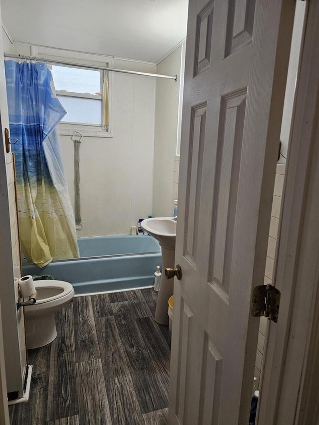 bathroom featuring toilet, hardwood / wood-style floors, and shower / bath combo with shower curtain