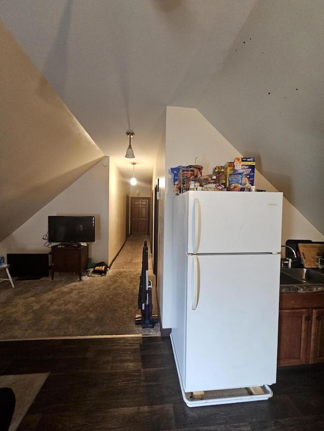 kitchen with sink, vaulted ceiling, dark hardwood / wood-style floors, and white refrigerator