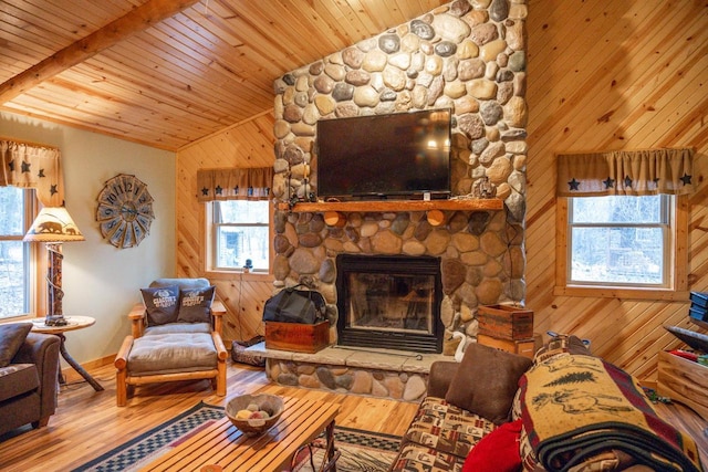 living room featuring lofted ceiling, wood walls, wooden ceiling, a fireplace, and hardwood / wood-style floors