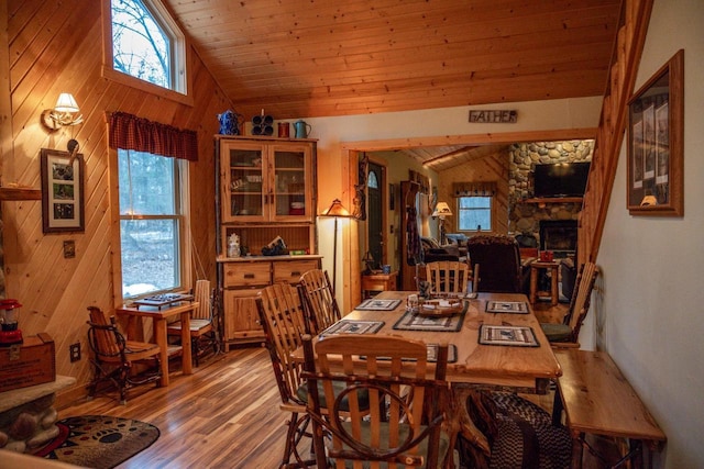 dining room featuring a wealth of natural light, vaulted ceiling, wooden ceiling, and wood-type flooring