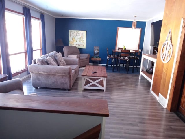 living room featuring crown molding, baseboards, and wood finished floors