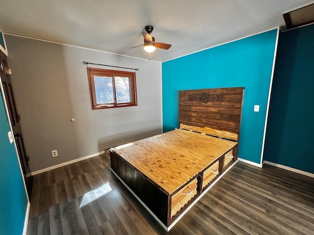 unfurnished bedroom featuring baseboards, dark wood-style floors, and a ceiling fan