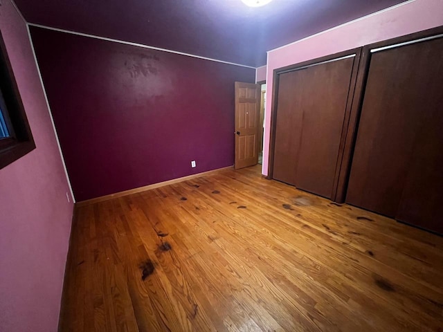 unfurnished bedroom featuring baseboards and wood finished floors