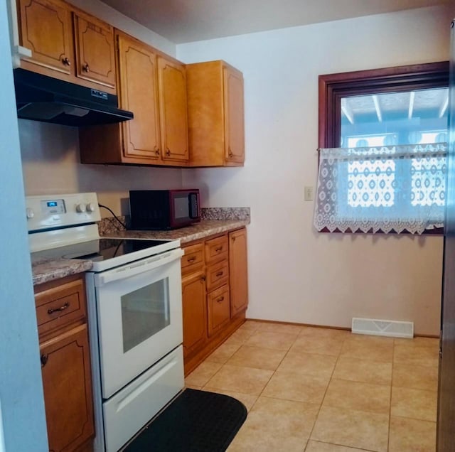 kitchen featuring light tile patterned floors, visible vents, under cabinet range hood, black microwave, and white electric range