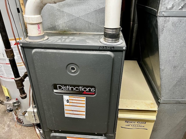 utility room featuring heating unit and water heater