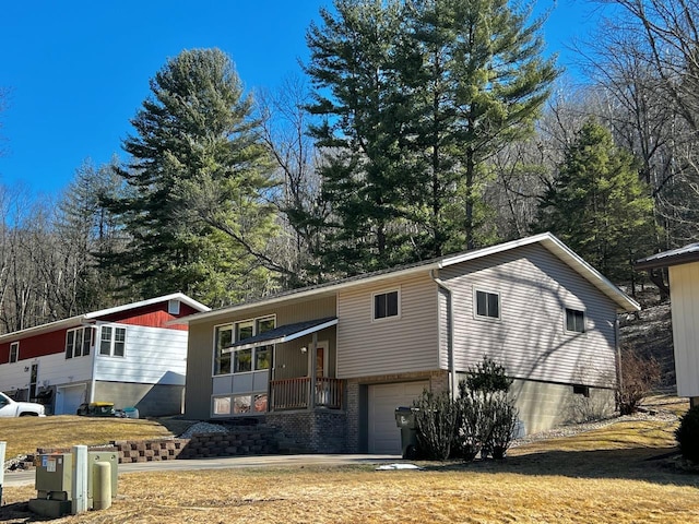 view of front of property featuring a front yard, an attached garage, and brick siding