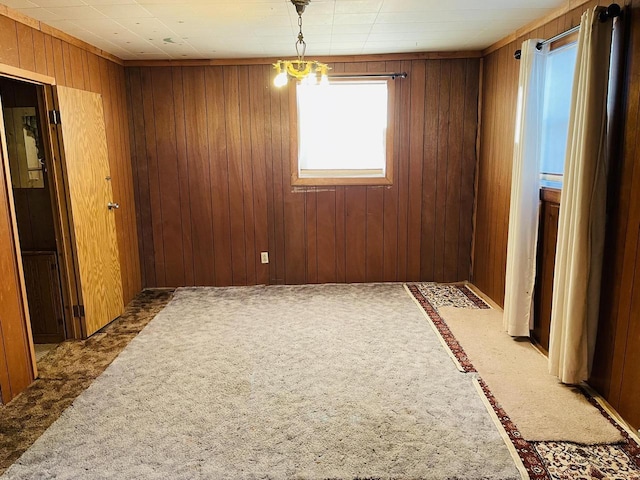 W7679 Oak St, Shiocton, WI 54170 - spare room with an inviting chandelier, dark carpet, and wooden walls