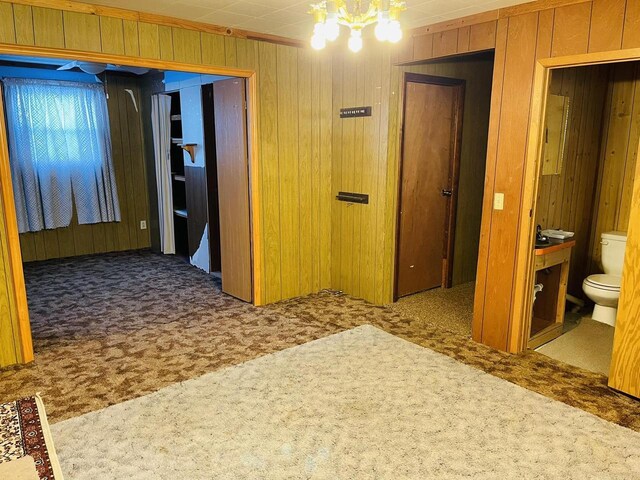 W7679 Oak St, Shiocton, WI 54170 - corridor with carpet, a notable chandelier, and wooden walls