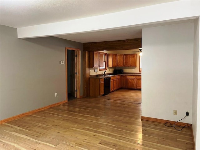 kitchen with hardwood / wood-style floors, beamed ceiling, sink, and black dishwasher