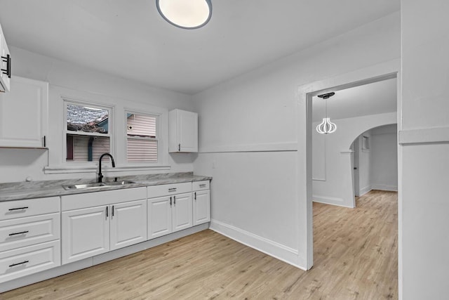 kitchen with light hardwood / wood-style floors, sink, and white cabinets