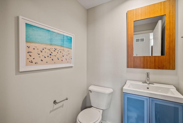 half bath with visible vents, vanity, and toilet