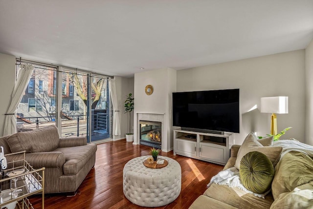 living room with a tile fireplace and dark wood finished floors