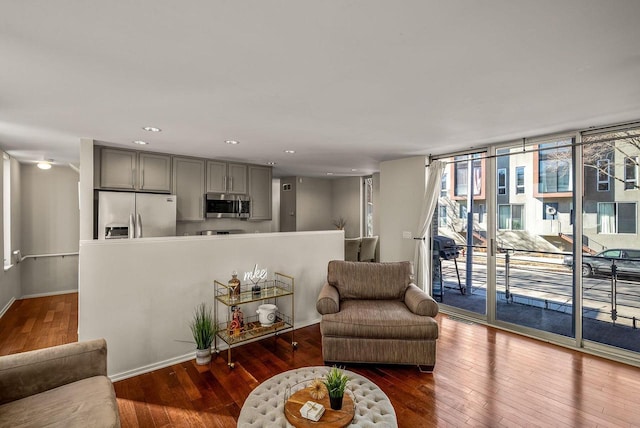 living room featuring recessed lighting, baseboards, dark wood finished floors, and expansive windows