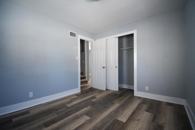 unfurnished bedroom with dark hardwood / wood-style flooring and a closet