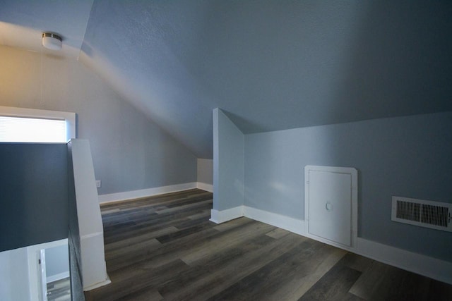 additional living space with dark hardwood / wood-style flooring and lofted ceiling