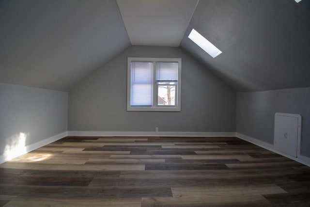 bonus room featuring dark hardwood / wood-style floors and lofted ceiling with skylight