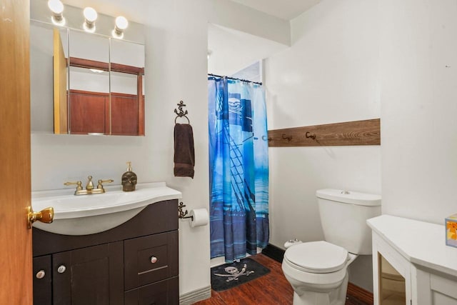 bathroom featuring toilet, wood-type flooring, curtained shower, and vanity