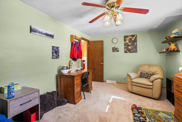 carpeted home office featuring ceiling fan