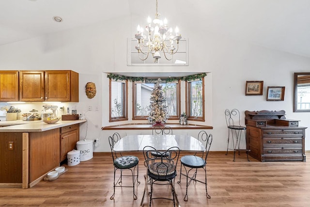 dining area featuring high vaulted ceiling, hardwood / wood-style floors, and a chandelier