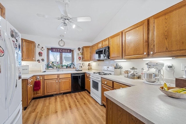 kitchen featuring sink, white appliances, vaulted ceiling, light hardwood / wood-style flooring, and ceiling fan