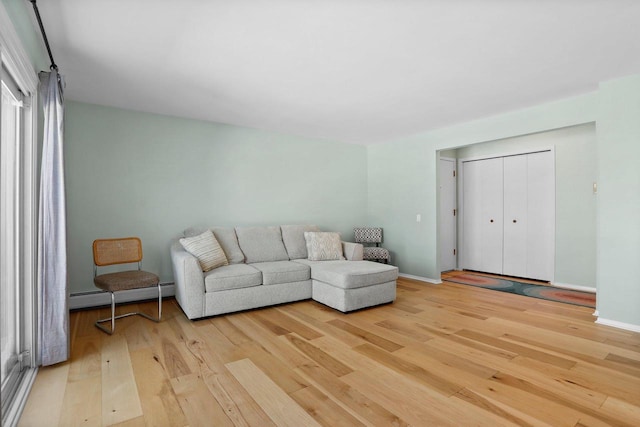 living room featuring a baseboard radiator and light hardwood / wood-style floors