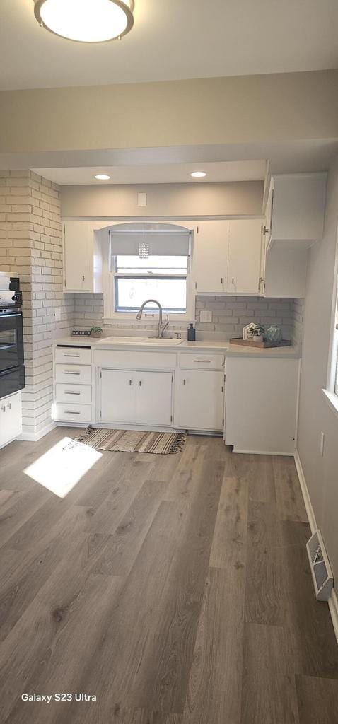 kitchen featuring tasteful backsplash, white cabinetry, dark hardwood / wood-style floors, and sink