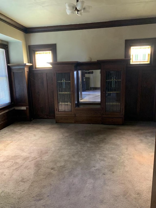 unfurnished living room featuring crown molding and light colored carpet