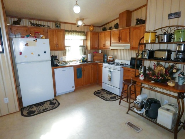 kitchen with white appliances, lofted ceiling, and sink