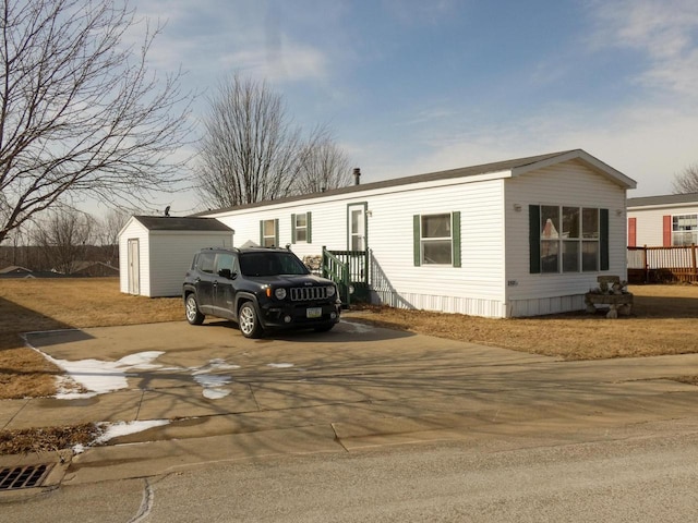 manufactured / mobile home featuring a garage and an outbuilding