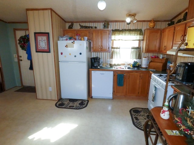 kitchen with ornamental molding, sink, and white appliances