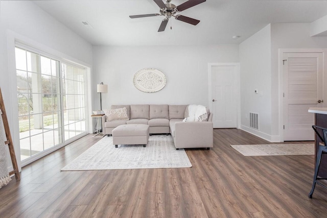 living room featuring wood-type flooring and ceiling fan