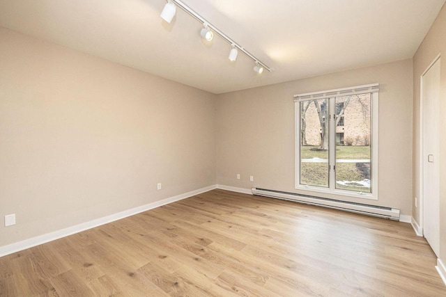 unfurnished room with light wood-style flooring, baseboards, and baseboard heating