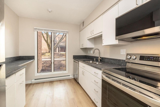 kitchen featuring a sink, white cabinetry, appliances with stainless steel finishes, baseboard heating, and light wood finished floors