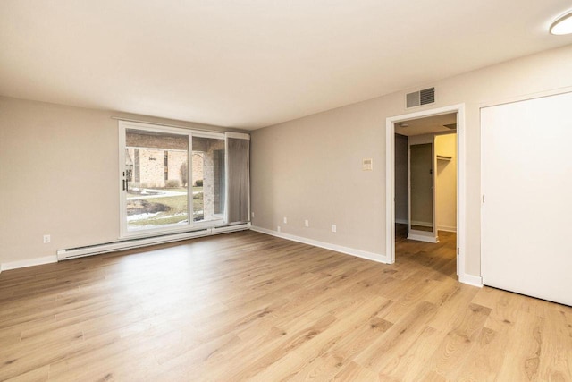 empty room with light wood-style floors, a baseboard radiator, visible vents, and baseboards