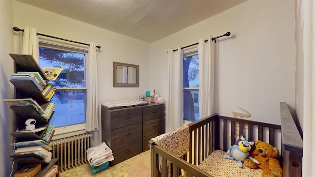 bedroom with a crib and radiator