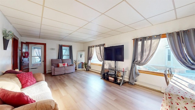 living room featuring a baseboard heating unit, a paneled ceiling, and light hardwood / wood-style floors