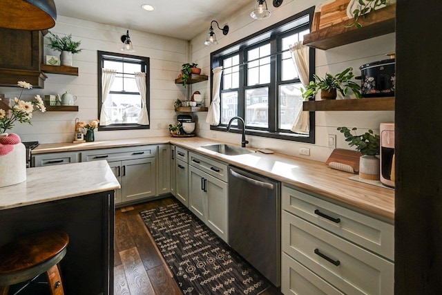 kitchen featuring dishwasher, open shelves, dark wood-style flooring, and a sink