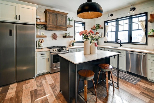 kitchen featuring stainless steel appliances, light wood-type flooring, light countertops, and open shelves