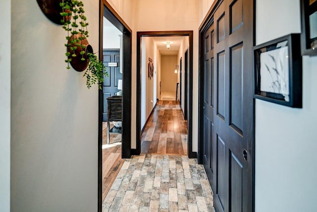 hall featuring brick floor and baseboards