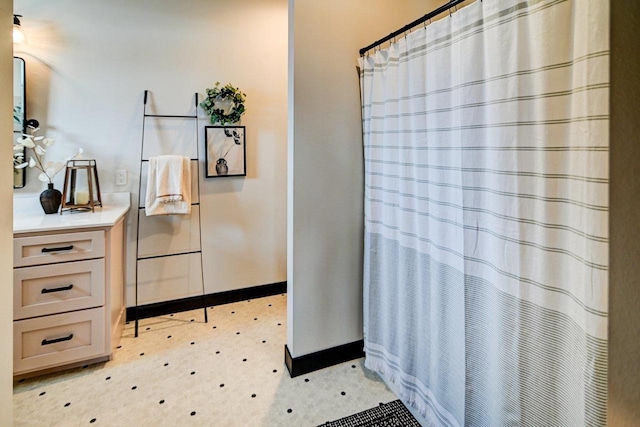 bathroom with a shower with curtain, baseboards, and vanity