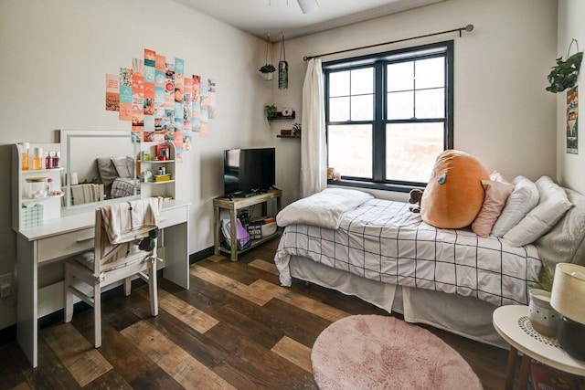 bedroom with baseboards and dark wood-type flooring