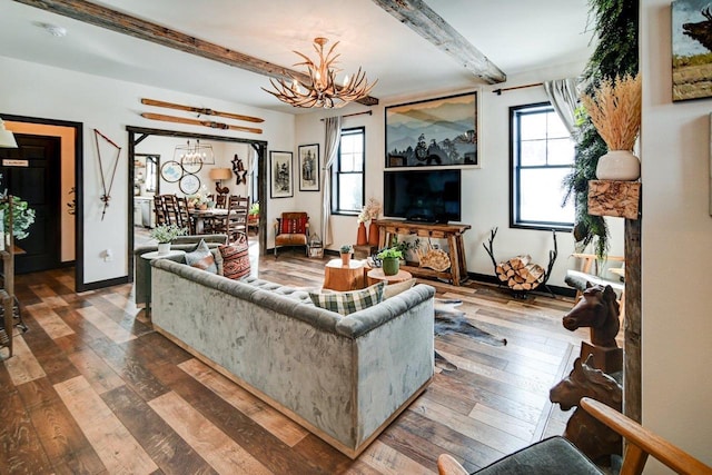 living area featuring a healthy amount of sunlight, a notable chandelier, and beamed ceiling