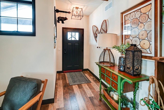 foyer featuring wood-type flooring, visible vents, and baseboards