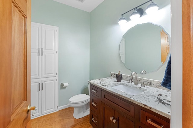 bathroom featuring vanity, wood-type flooring, and toilet