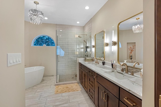 bathroom with independent shower and bath, vanity, and an inviting chandelier