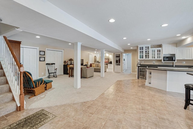 kitchen with light carpet and white cabinets