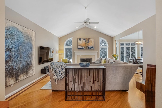 living room featuring ceiling fan, lofted ceiling, and light hardwood / wood-style floors