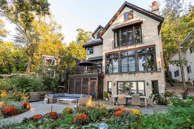 rear view of house with a patio area, an outdoor hangout area, a chimney, and a balcony